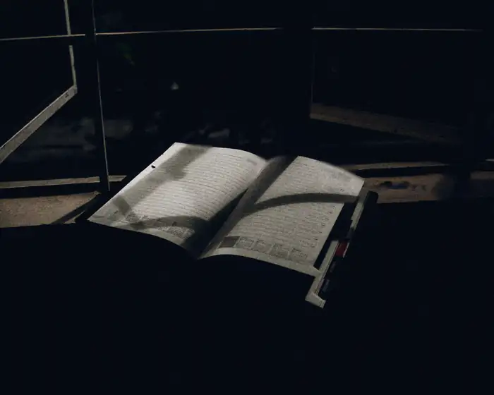 A week planner lying open on a window ledge at night, the page lit by one light